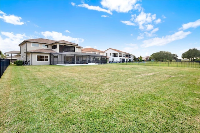 back of house featuring a lawn, a tile roof, and a fenced backyard