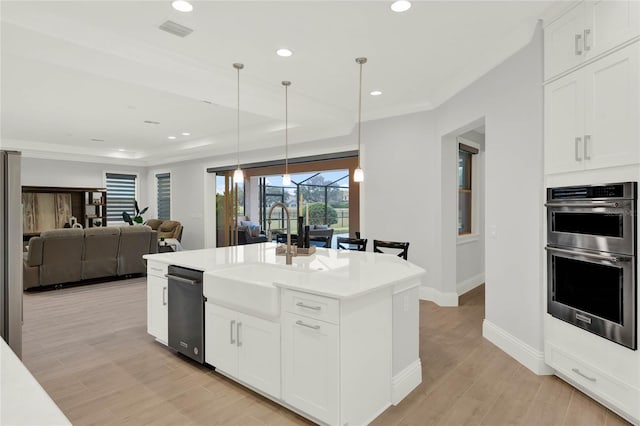 kitchen featuring recessed lighting, visible vents, light wood-style floors, stainless steel double oven, and a sink