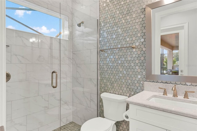 bathroom featuring vanity, tasteful backsplash, a shower stall, and a wealth of natural light