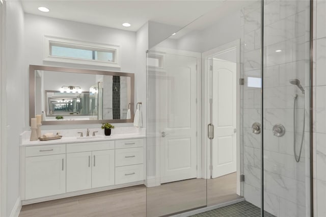 bathroom with a shower stall, vanity, and recessed lighting