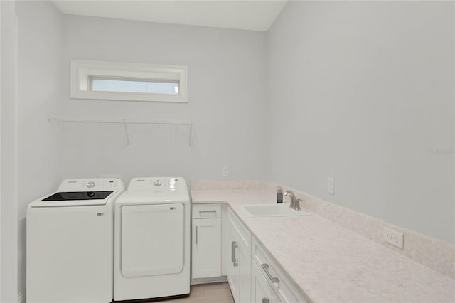 washroom featuring cabinet space, a sink, and separate washer and dryer