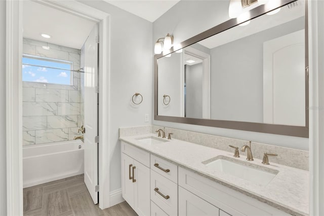 bathroom with tub / shower combination, a sink, and double vanity