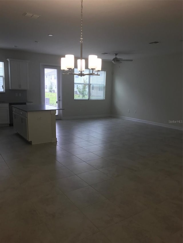 unfurnished room featuring tile patterned flooring and ceiling fan with notable chandelier