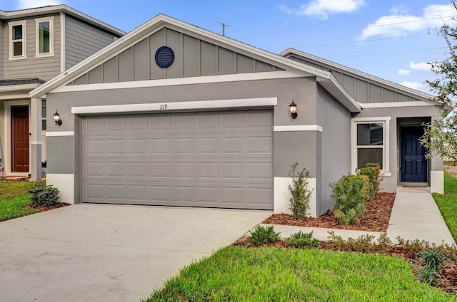 view of front of property with an attached garage, driveway, board and batten siding, and stucco siding