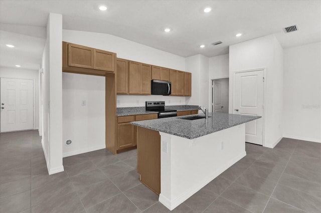 kitchen with an island with sink, visible vents, appliances with stainless steel finishes, and brown cabinets