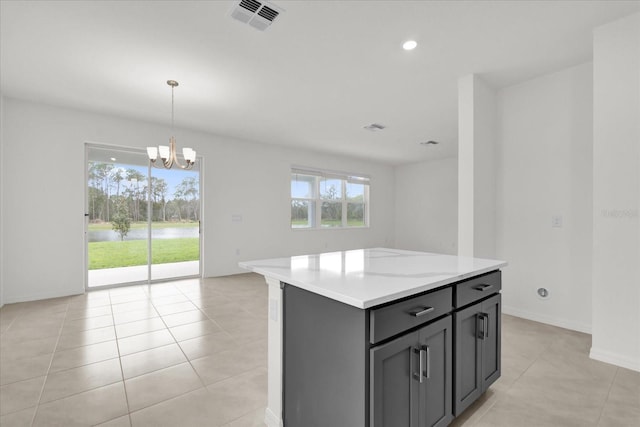 kitchen with visible vents, open floor plan, decorative light fixtures, a center island, and a notable chandelier