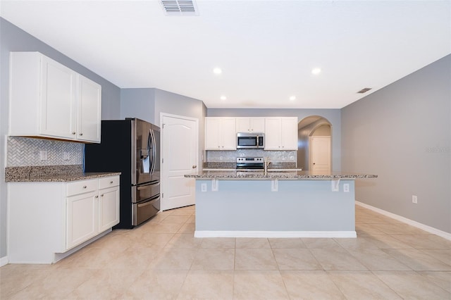 kitchen with dark stone countertops, white cabinetry, and appliances with stainless steel finishes