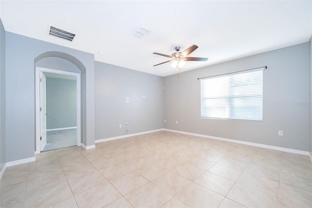 tiled empty room featuring ceiling fan