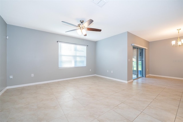 spare room featuring ceiling fan with notable chandelier and light tile patterned floors