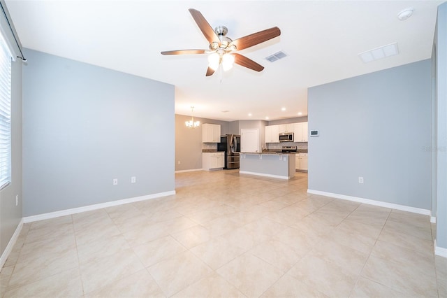 unfurnished living room featuring ceiling fan with notable chandelier and light tile patterned flooring