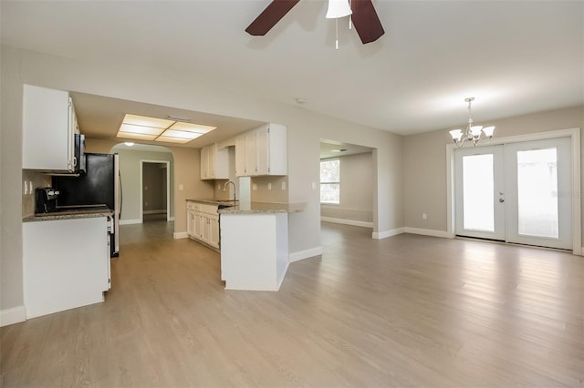 kitchen with ceiling fan with notable chandelier, white cabinetry, sink, and light hardwood / wood-style flooring