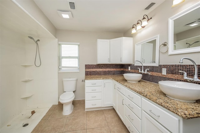 bathroom with walk in shower, tasteful backsplash, tile patterned flooring, toilet, and vanity