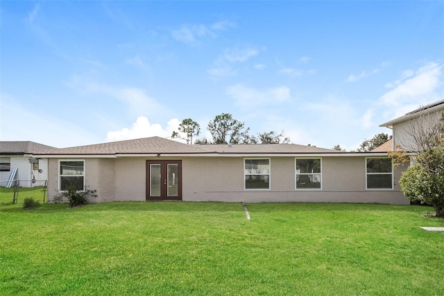 back of house with french doors and a lawn