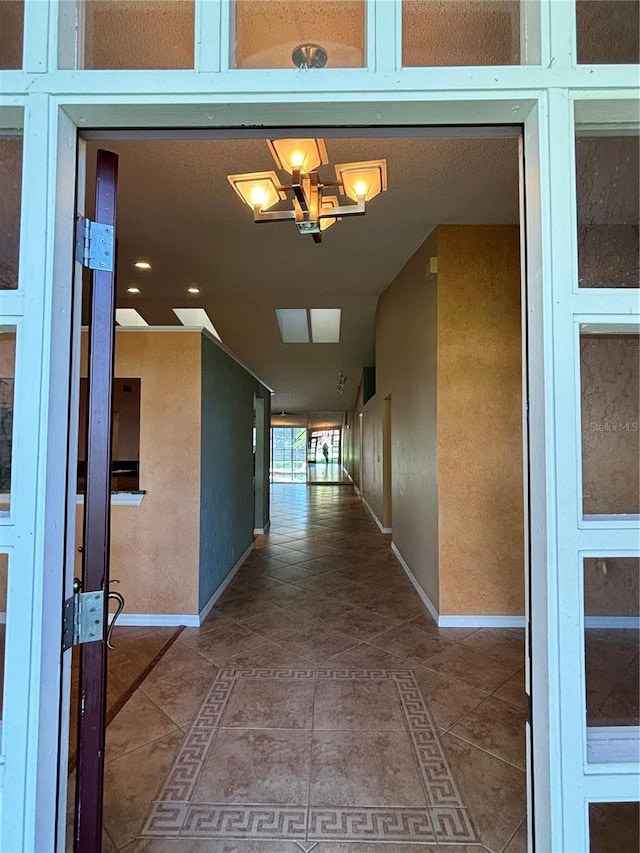 hall featuring a notable chandelier and tile patterned floors