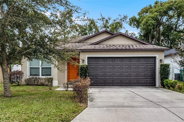 ranch-style house featuring a front lawn and a garage