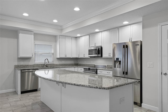 kitchen featuring appliances with stainless steel finishes, sink, white cabinetry, and a center island