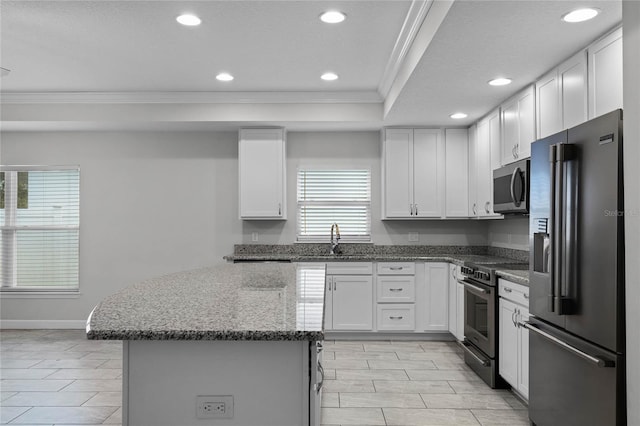 kitchen featuring white cabinetry, stainless steel appliances, and dark stone countertops