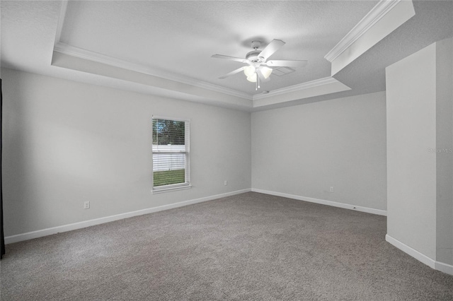 spare room featuring ceiling fan, carpet floors, a tray ceiling, a textured ceiling, and ornamental molding