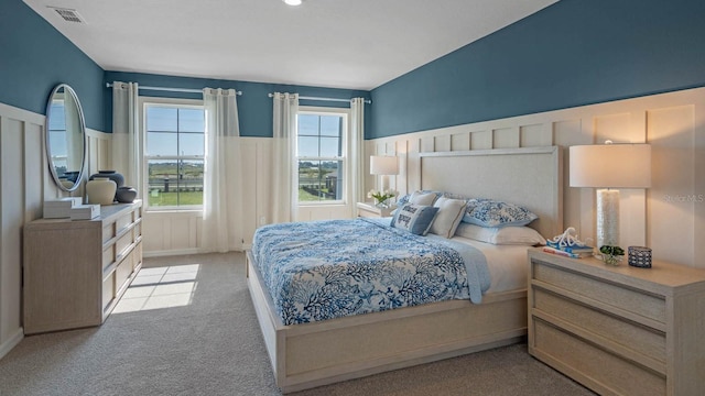 bedroom featuring light carpet and multiple windows