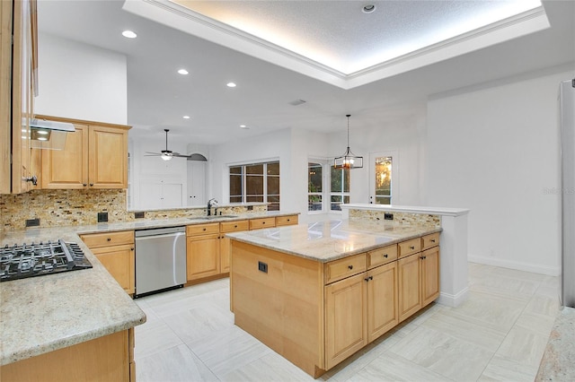 kitchen with appliances with stainless steel finishes, light stone counters, ceiling fan with notable chandelier, a center island, and hanging light fixtures