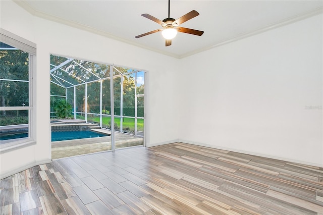 empty room with light hardwood / wood-style floors, ceiling fan, and crown molding