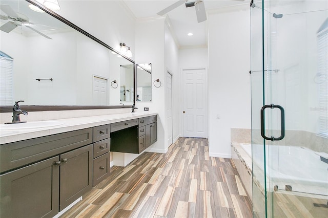 bathroom with ceiling fan, separate shower and tub, hardwood / wood-style floors, vanity, and ornamental molding