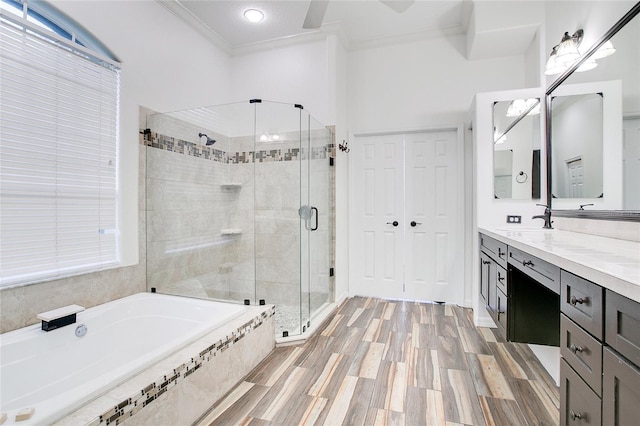 bathroom featuring vanity, crown molding, hardwood / wood-style floors, and plus walk in shower