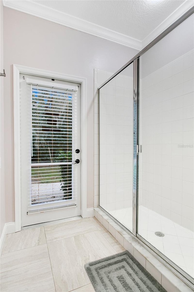 bathroom featuring tile patterned flooring, a textured ceiling, a shower with door, and crown molding