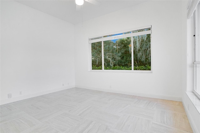 unfurnished room featuring ceiling fan and a wealth of natural light