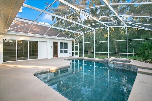 view of swimming pool featuring glass enclosure, a patio area, and an in ground hot tub