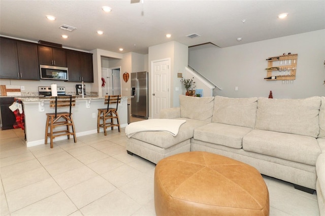 tiled living room featuring sink