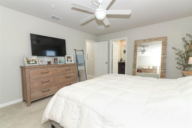 bedroom featuring ceiling fan, light colored carpet, and ensuite bathroom