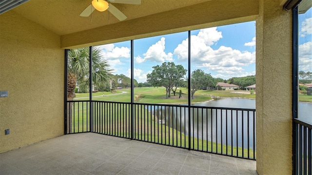 unfurnished sunroom featuring ceiling fan, plenty of natural light, and a water view