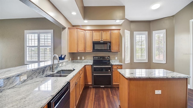 kitchen featuring black appliances, sink, dark hardwood / wood-style floors, light stone counters, and kitchen peninsula