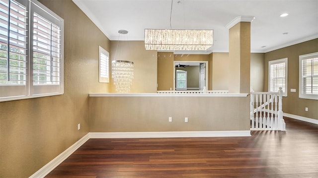 empty room with crown molding, dark wood-type flooring, ceiling fan, and a healthy amount of sunlight