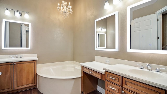 bathroom with vanity, an inviting chandelier, and a bathtub