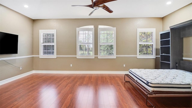 unfurnished bedroom with ceiling fan and hardwood / wood-style floors