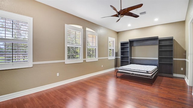 unfurnished bedroom featuring ceiling fan and dark wood-type flooring