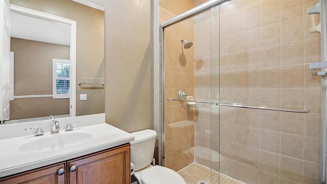 bathroom featuring vanity, toilet, and walk in shower