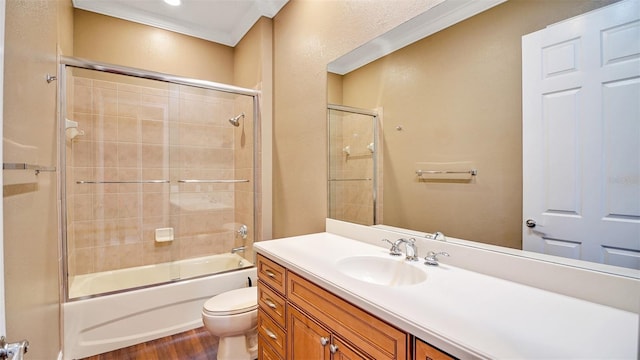 full bathroom featuring vanity, toilet, crown molding, and bath / shower combo with glass door