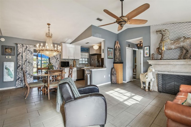 living room with ceiling fan with notable chandelier and lofted ceiling