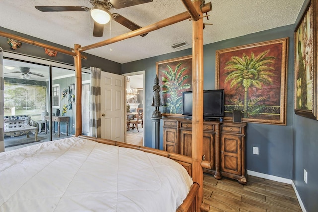 bedroom with ceiling fan, hardwood / wood-style floors, and a textured ceiling