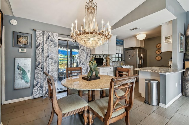 dining area with baseboards, wood finish floors, visible vents, and a notable chandelier