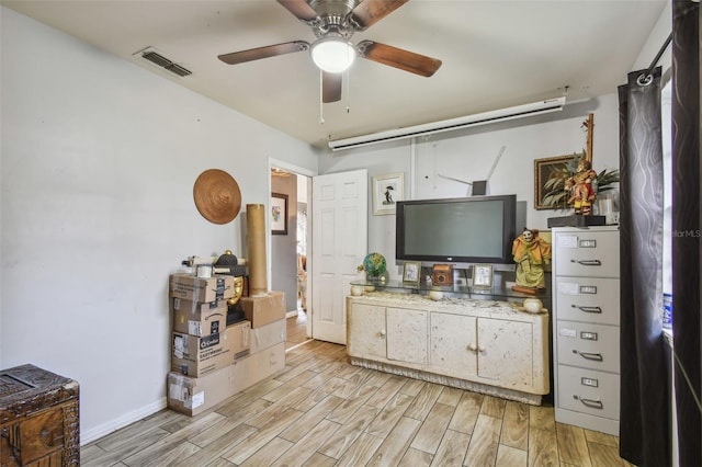 interior space featuring a ceiling fan, wood tiled floor, visible vents, and baseboards