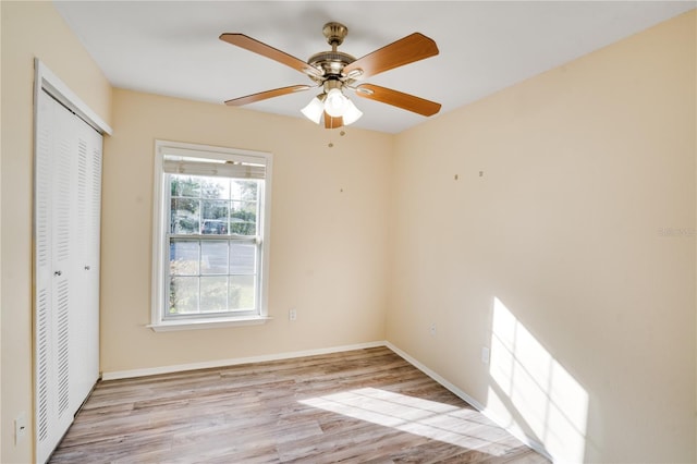 unfurnished bedroom featuring ceiling fan, light wood-type flooring, and a closet