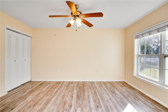 unfurnished bedroom featuring ceiling fan, a closet, and light hardwood / wood-style flooring