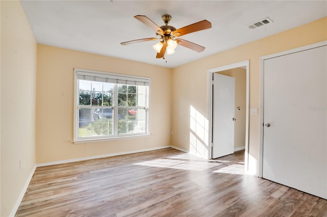 unfurnished room with ceiling fan and light wood-type flooring