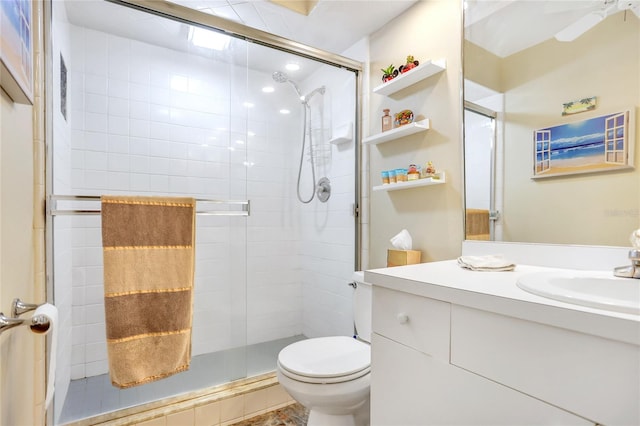 bathroom featuring tile patterned floors, walk in shower, vanity, ceiling fan, and toilet