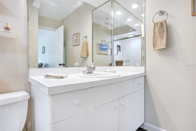 bathroom with vanity, toilet, and ceiling fan