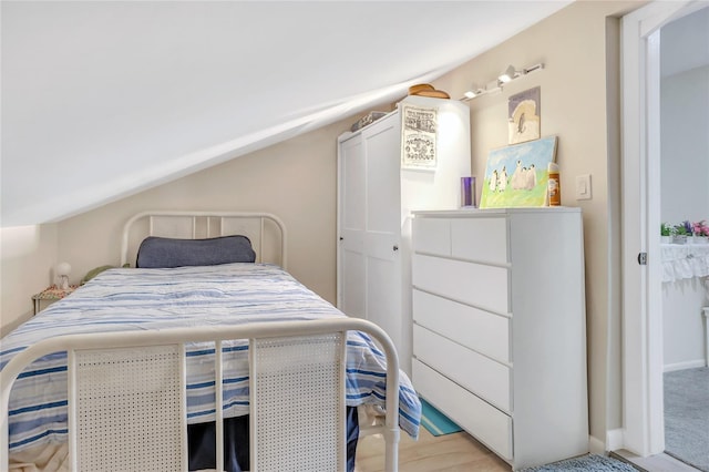 bedroom featuring light hardwood / wood-style floors and lofted ceiling